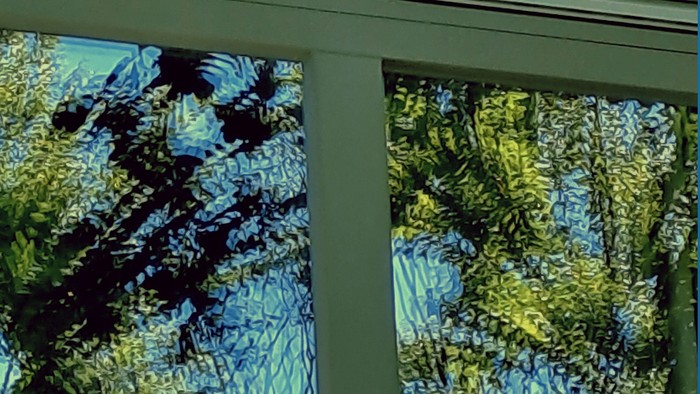 Durch das grüne Fenster sieht man Bäume und Büsche.