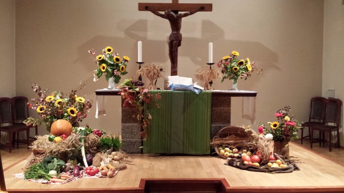Der Altar in einer Kirche ist mit Blumen und Kerzen geschmückt