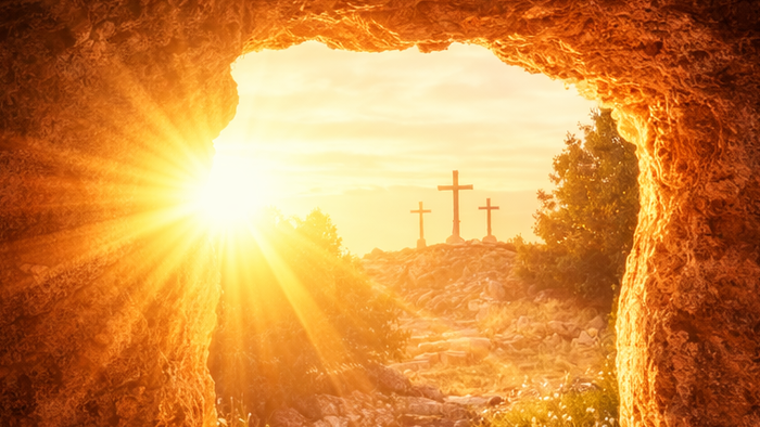 Solbelyst gravindgang afslører tomme ligklæder med kors, der gløder i baggrunden.