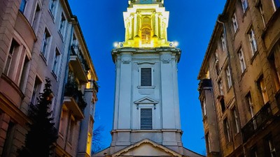 Hoch aufragender beleuchteter Turm zwischen Gebäuden