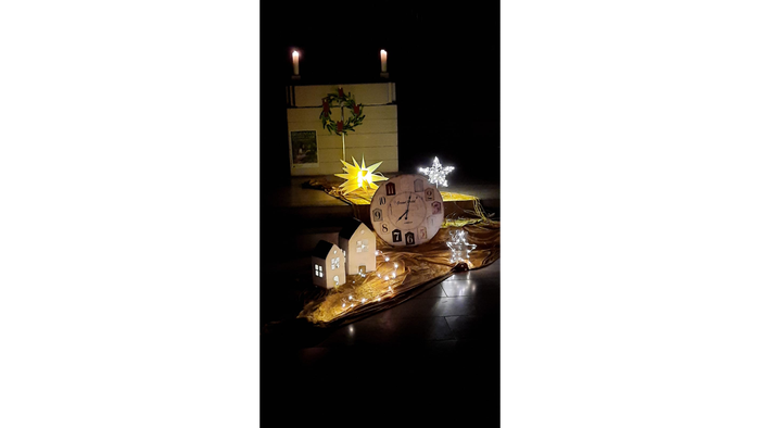 Ein Weihnachtszweibrenner mit Kerzen und Lichterketten auf einem dunklen Hintergrund