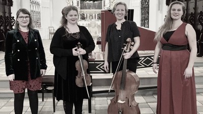 Et kvartet musikere med strygeinstrumenter poserende sammen indendørs.