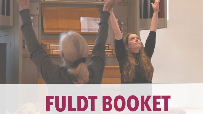 To personer løfter armene i en kirkelig sammenhæng og promoverer arrangementet eller udgivelsen "Fuldt Booket".