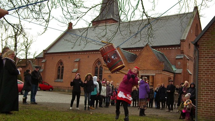 En gruppe børn spiller med en kasse udenfor en kirke.