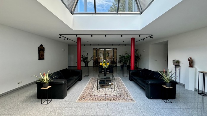 Modernes Wohnzimmer mit großen Fenstern und schwarzen Möbeln