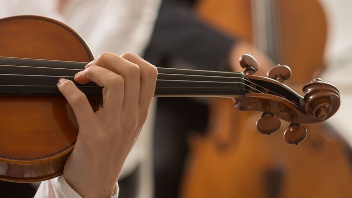 Hände eines Geige spielenden Kindes