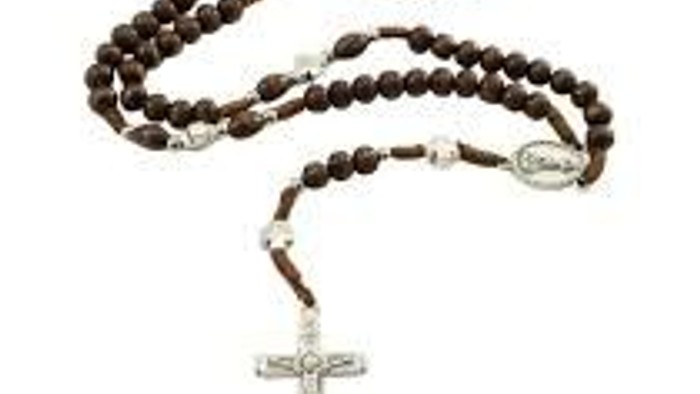 Ein Rosenkranz mit Holzperlen und silbernem Kreuz.