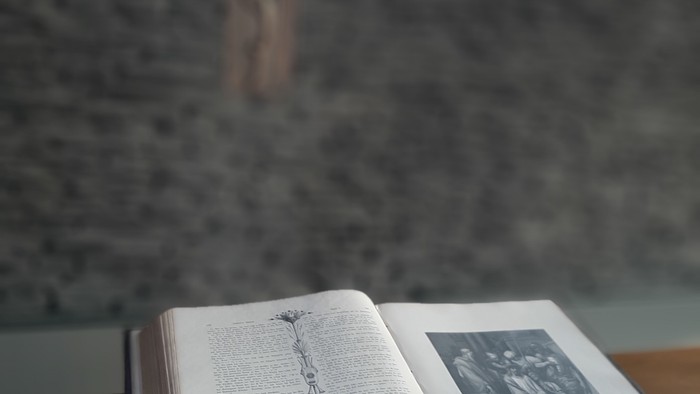 Offenes Buch mit Kreuz im Hintergrund