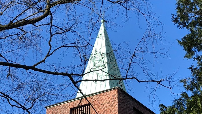 Kirchturm mit Zweigen ohne Blätter daran