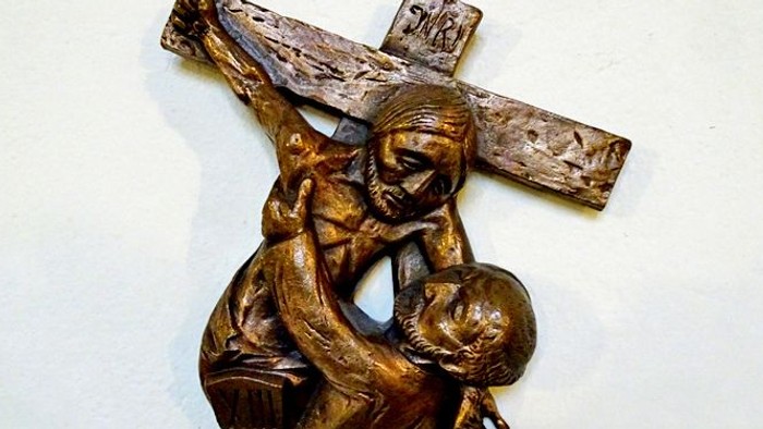 Die Bronzestatue zeigt Jesus Christus mit Kreuz.