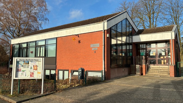 Modernes Gebäude mit Glasfenstern und Ziegelfassade, Schild vorne