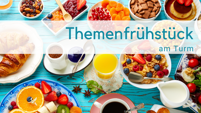 Hellblauer Holztisch mit Frühstückszutaten: O-Saft, Milchkännchen, obst, Cerealien, Tomaten, Croissant, Törtchen