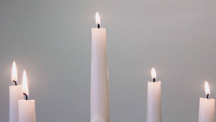 Firelyse på tavler foran mørk vegg