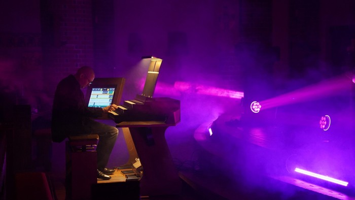 Dirk Elsemann beim Orgelspiel mit lila Scheinwerferlicht
