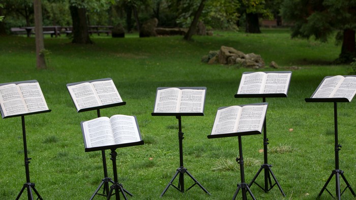 Mehrere Notenständer mit Notenblättern im Park