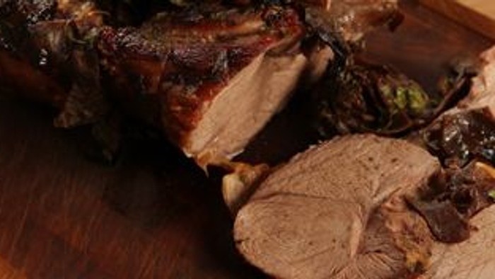 En stykket svinekødt på brædder med en kniv ved siden.