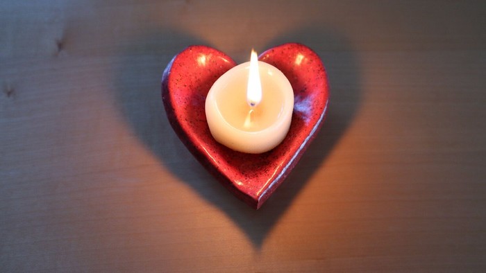 Ein beleuchtetes Herz steht auf einem Holztisch.