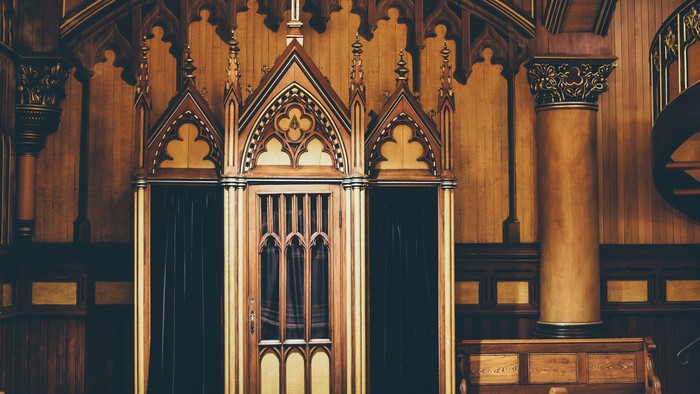 Ornate Holzvertäfelung mit Kreuz und Säulen in Kirche