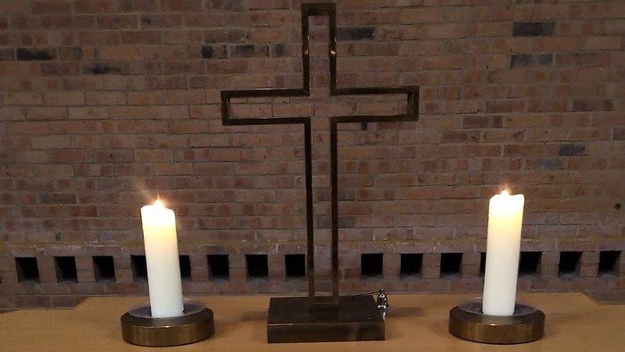 Offene Bibel mit Kreuz und Kerzen