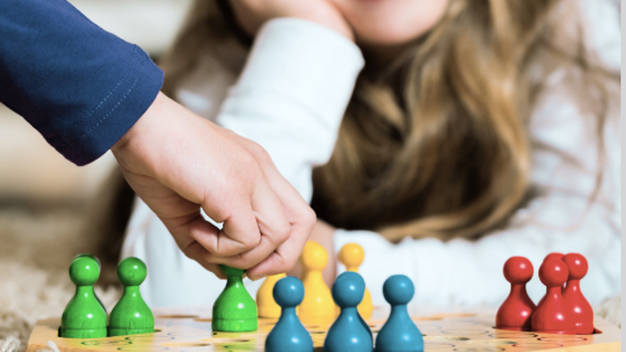 Plakat zur Bewerbung eines Familien-Brettspiel-Nachmittags mit Kindern, die am 28. März 2026 Spiele spielen.