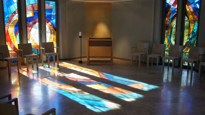 Farbenfrohe Kirchenfenster werfen bunte Schatten auf den Boden