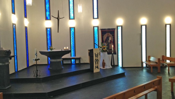 Kirchlicher Innenraum mit Altar und Bänken