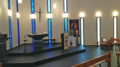 Kirchlicher Innenraum mit Altar und Bänken