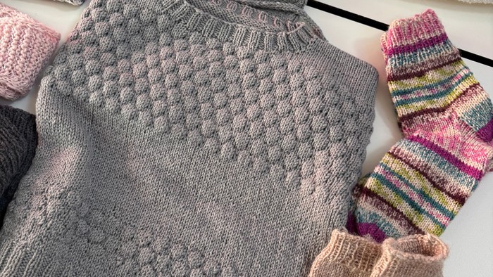 Nørklerne. Strikkeklub. Foto af strikket trøje, sokker og handsker