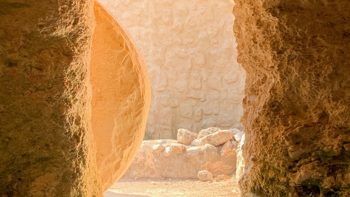 Ein alter, verwitterter Torbogen aus Stein, der in die Ferne führt