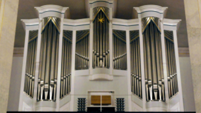 Elegante Pfeifenorgel mit symmetrischen schwarz-weißen Pfeifen und dekorativen goldenen Akzenten in einem prächtigen Ambiente.