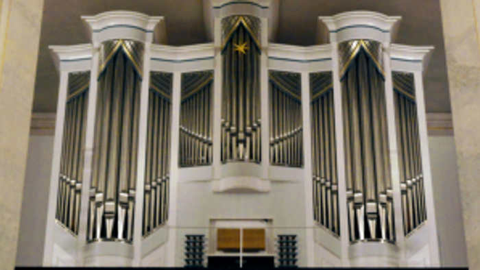 Elegante Pfeifenorgel mit symmetrischen schwarz-weißen Pfeifen und dekorativen goldenen Akzenten in einem prächtigen Ambiente.