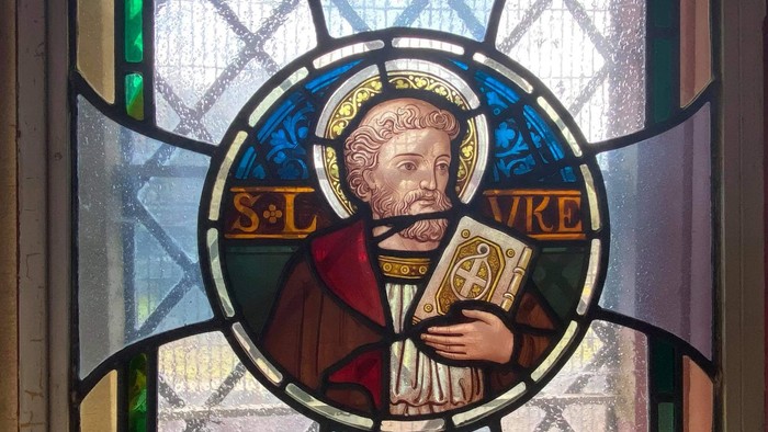 Stained glass portrait of a man holding a book, presented by Rev. Golding Bird in 1955