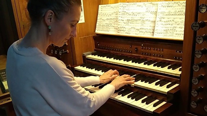 Kvinde spiller orgel i kirke