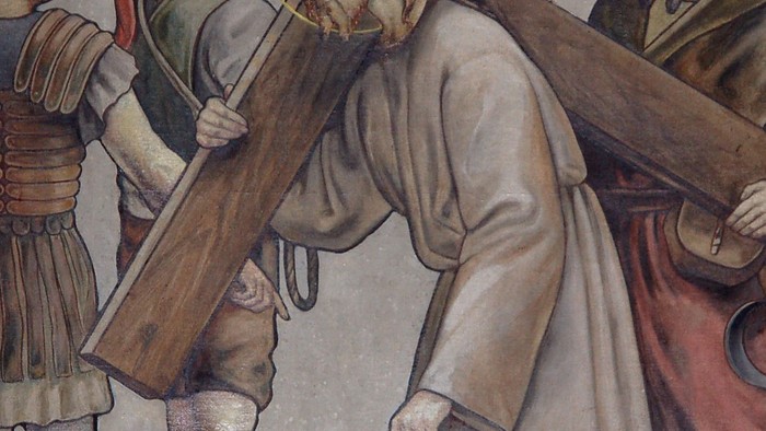 Jesus trägt das Kreuz, begleitet von zwei Männern und einer Frau.