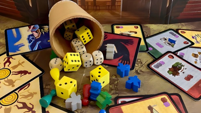 Bunte Würfel und Spielsteine auf einem Tisch mit verschiedenen Spielkarten