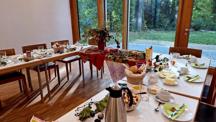 Ein gemütlicher Speisesaal mit zwei Tischen, die für ein Frühstück oder ein kleines Buffet gedeckt sind.