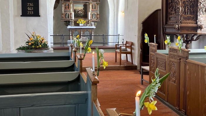 Indre del af kirke med alter og bænke.