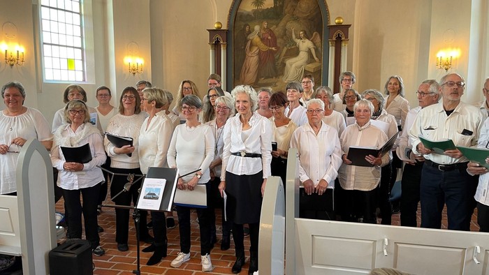 En kor stander i kirke med noter i hænderne