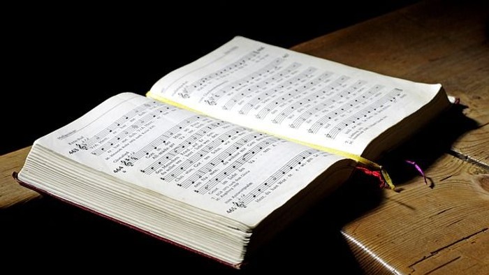 Offenes Buch mit Noten auf Holzoberfläche
