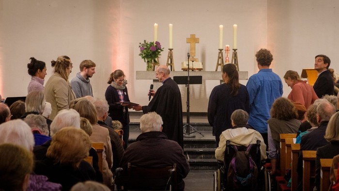 Eine Gruppe von Menschen nimmt an einer religiösen Zeremonie in einer Kirche teil.