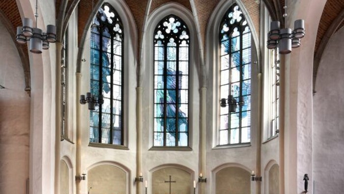 Kircheninneres mit Buntglasfenstern und Kirchenbänken