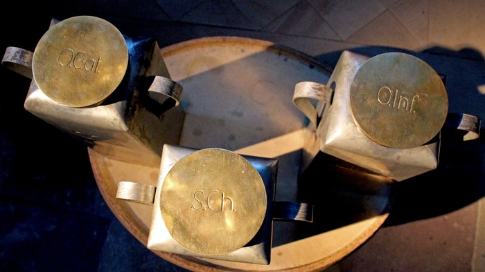 Drei goldfarbene Metallbecher auf einem Tablett