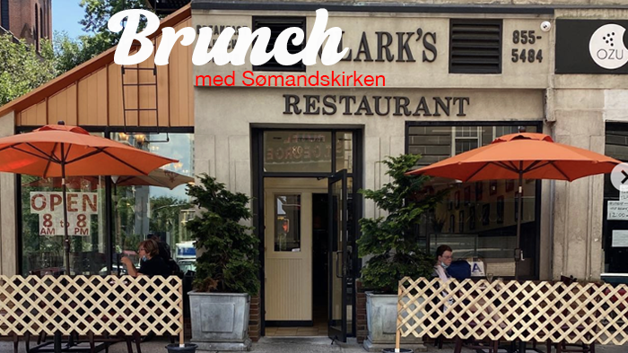 Charmerende restaurant ved navn Brunch at Lark's med udendørsservering under orange parasoller.