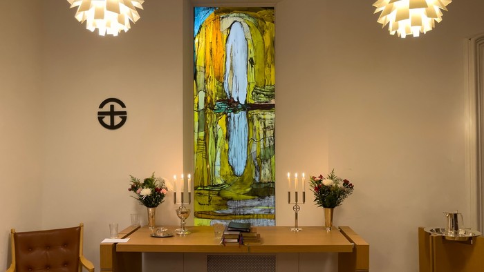 Indretning med moderne lys, maleri og bord med blomster og lyse candlestick.