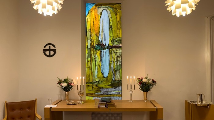 Indretning med moderne lys, maleri og bord med blomster og lyse candlestick.