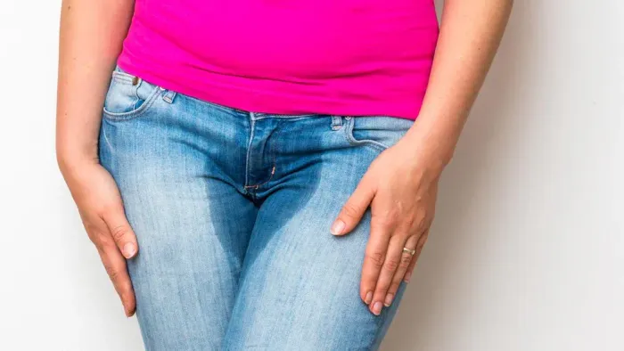 Kvinde med våde bukser pga inkontinens.