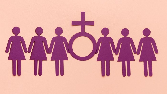 Sechs Frauen halten Hände und bilden ein Kreuz mit Symbol