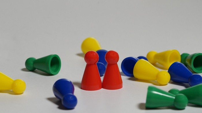 Bunte Plastikstifte in verschiedenen Formen auf einer schlichten Oberfläche verstreut.