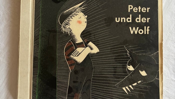 Buchcover für Kinder zu „Peter und der Wolf“ von Sergei Prokofjew mit einem Jungen und einem Wolf.