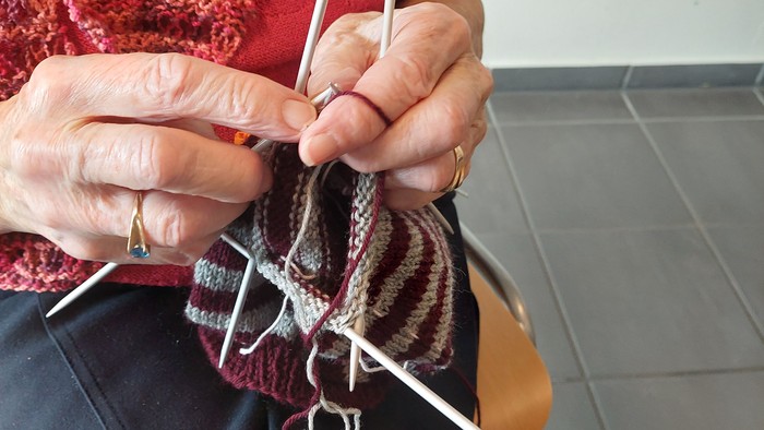 En person sitter og stråler en stribetøj med stråler.